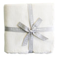Ivory moss stitch baby blanket folded neatly on a white background.