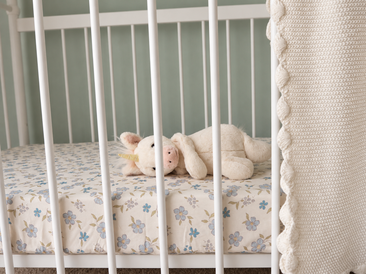 Forget Me Not floral cot sheet styled in a baby's nursery