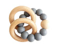 Teething ring with wooden rings and gray silicone beads on a white background